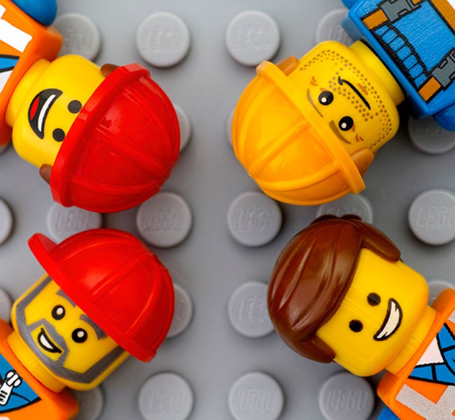 Still from lego movie with builders lying on a lego background