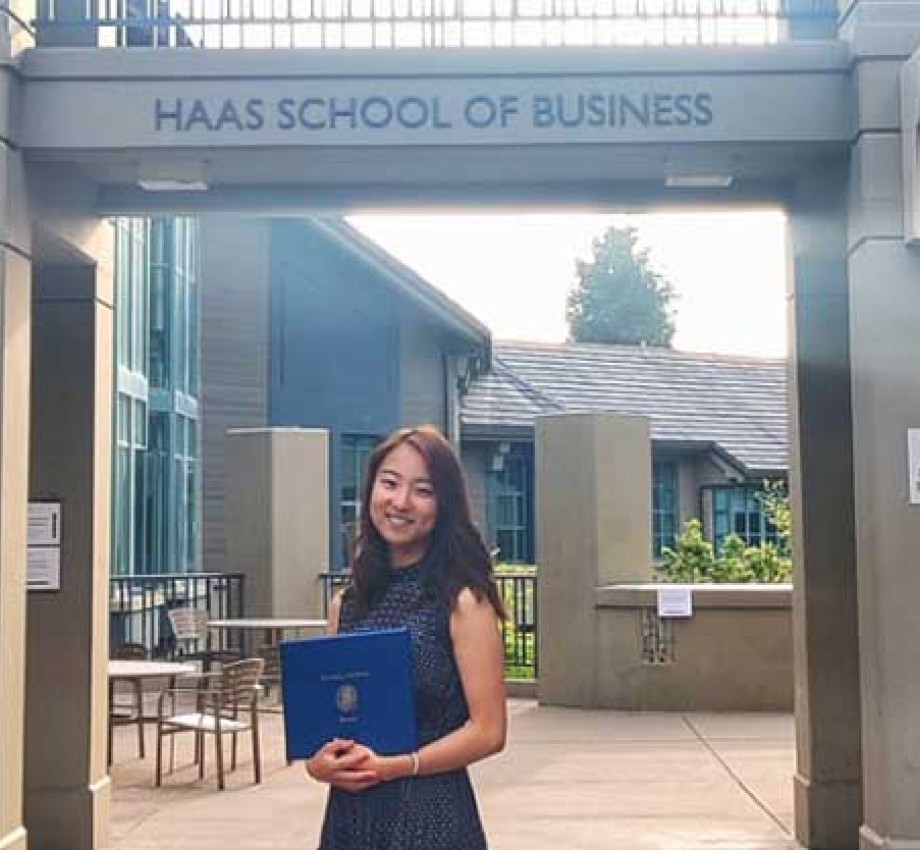 Photo of student Rioko Enomoto standing under Haas School of Business sign