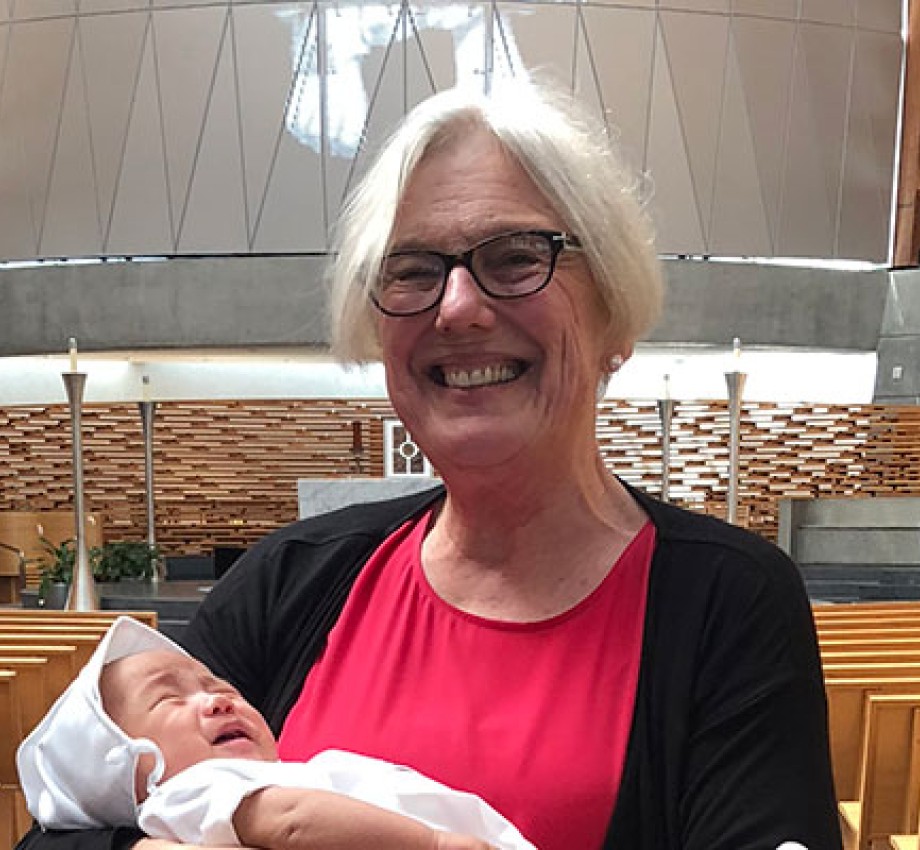 Photograph of Alcohol and Drug Abuse Studies graduate Therese Becker holding her grandson at his baptism