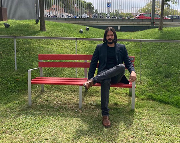 Photo of Dany Bonaventura sitting on a red fence