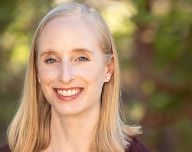 Headshot of Lauren Jesse in front of a wood background