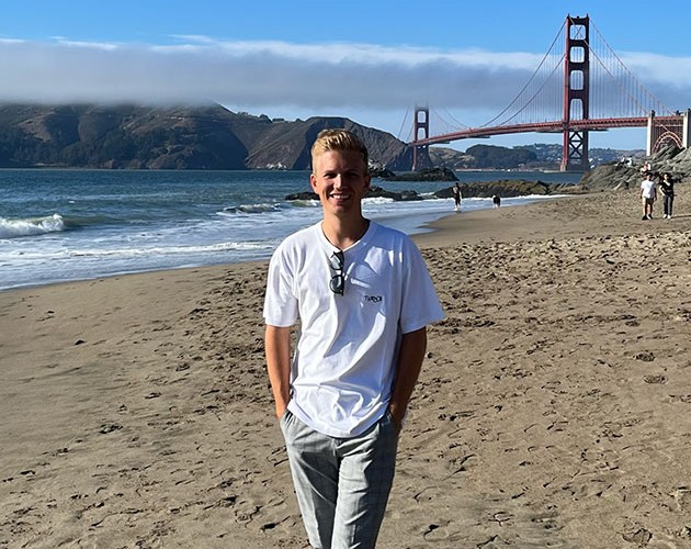 Photo of Lorenz Hieber in front of the golden gate bridge at the beach