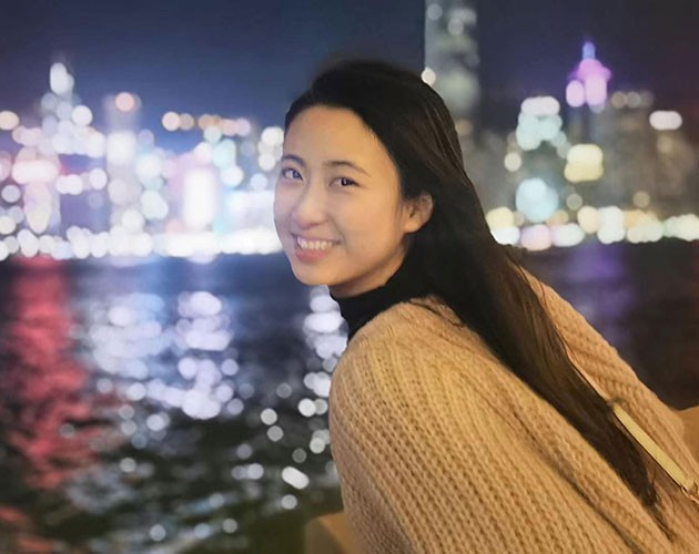 Vera Guo leaning across railing in New York City