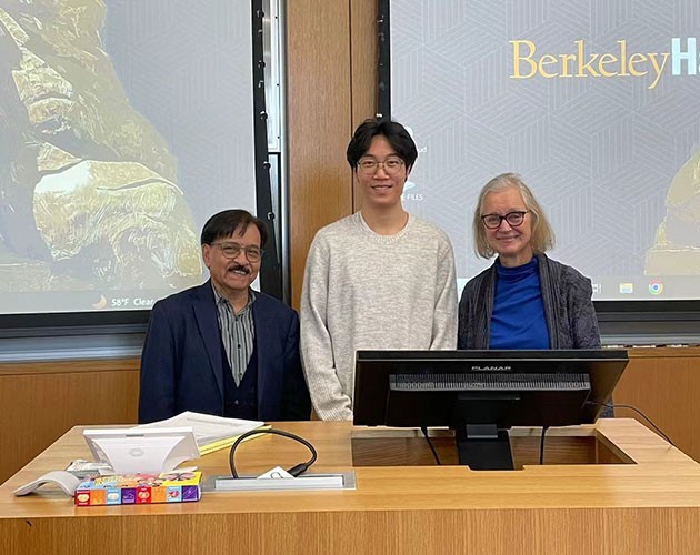 Zhong Li and two professors take a photo inside a Berkeley Haas classroom