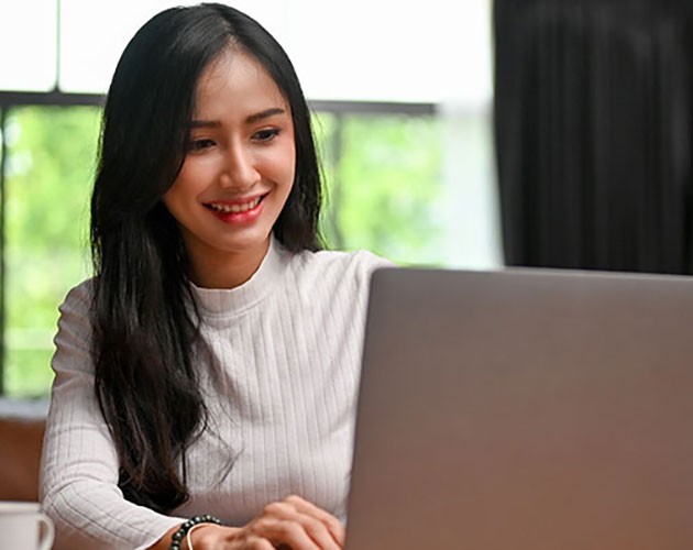 young woman writing on a laptop