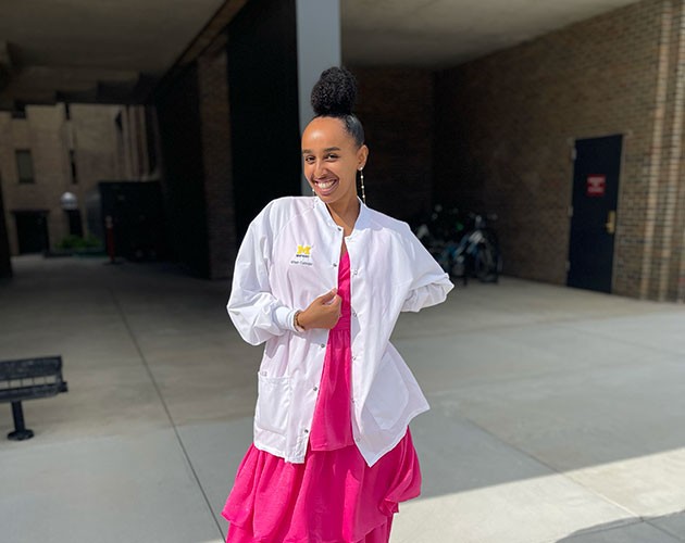 Photo of Brhan Eskinder wearing white lab coat in front of a building