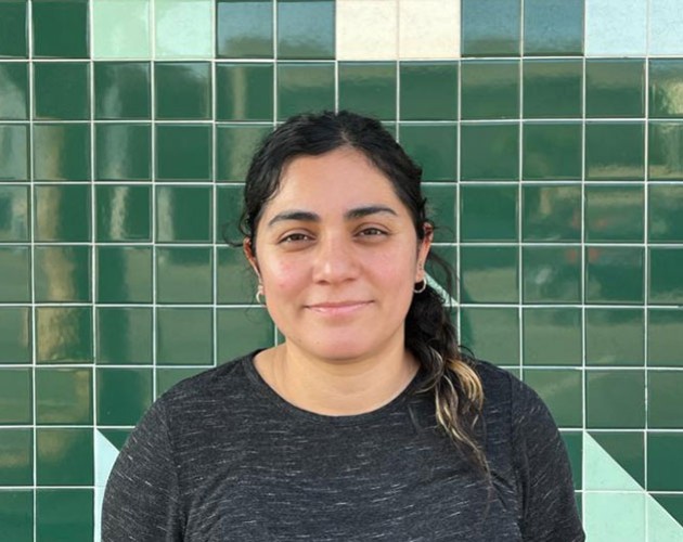 Headshot of Lucia Moreno in front of a green tile background