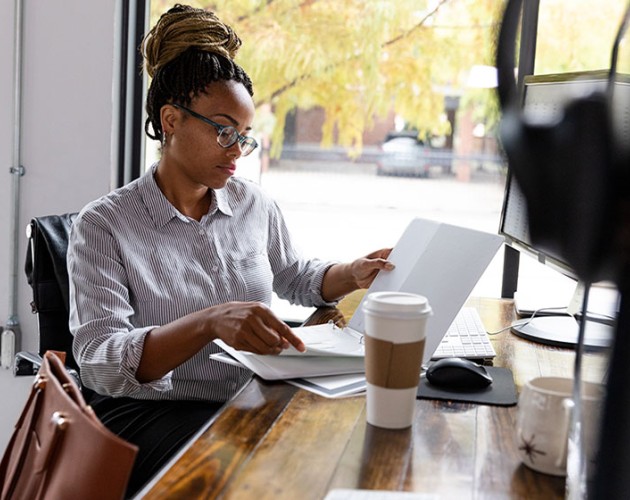 Black young female professional working on laptop from a coffee shop