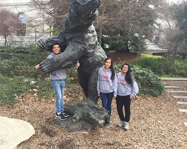 Luis Aguirre and friends posing behind a tree on UC Berkeley campus