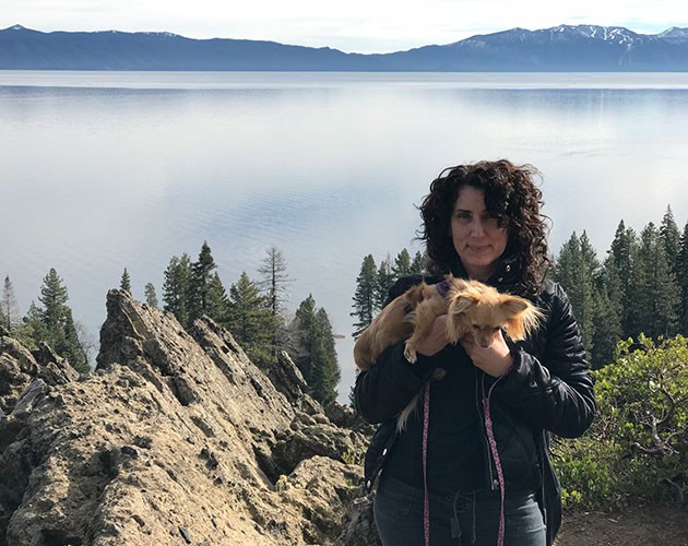 Photo of Marianna Lenoci holding her dog in front of a lake