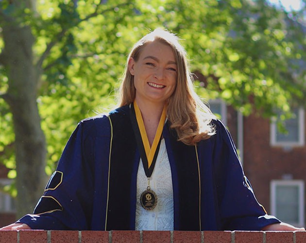 Post-Baccalaureate Health Professions Program alumna Anne Chiruvolu wearing graduation robes