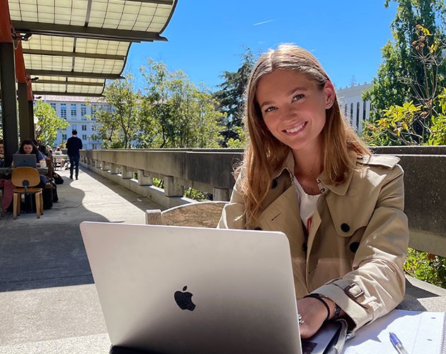 Photo of Sarah Larsen studying outside in front of a laptop