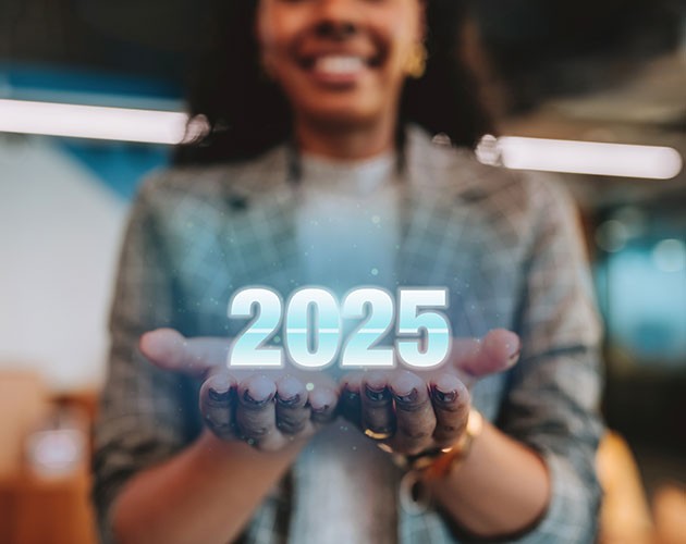 Young female professional holding hologram of 2025 