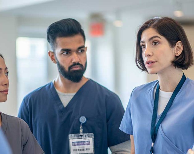 Group of nursing standing in a circle having a meeting