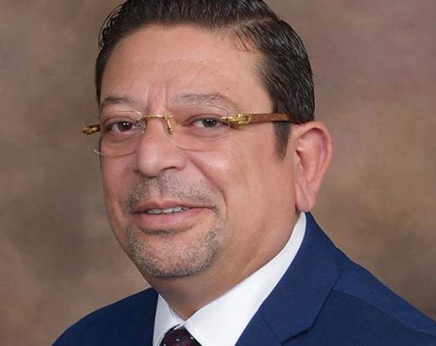 Headshot of UC Berkeley Extension accounting instructor Dr. Ehab Saad wearing a dark bue suit with brown background