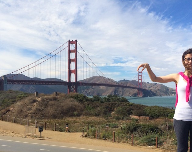 Graduate Maria Paula poses playfully in front of the Golden Gate bridge