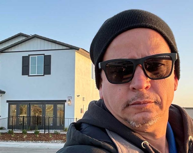 Selfie of Juan Resendes standing in front of a house