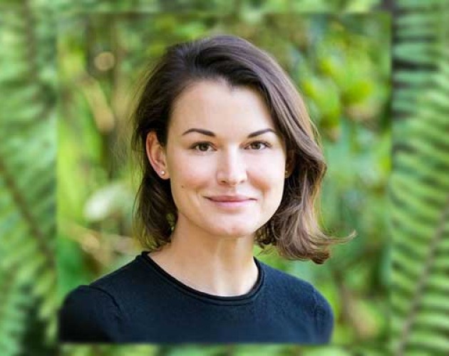 Headshot of Kseniya Norkina in front of foliage background