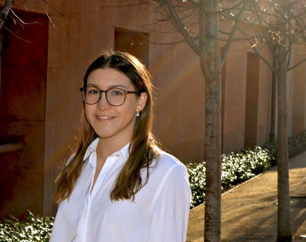 UX design professional Macarena Muniz standing in a shaft of light