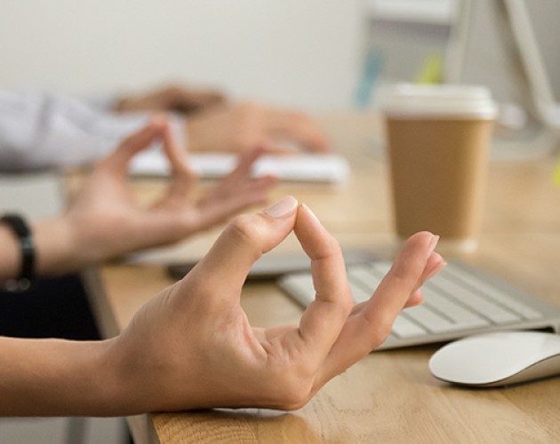 Hands of employee at the work place in meditative posture