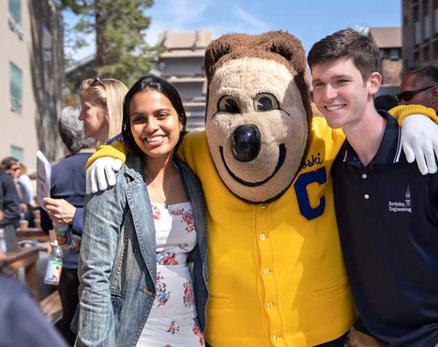 Two Berkeley students posing with Oski Bear in front of the camera