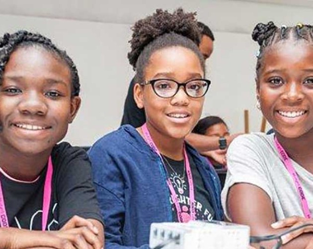 Image of three young black girls smiling at the camera