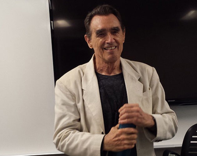 Writing instructor and poet Clive Matson standing in the front of a classroom at UC Berkeley Extension in San Francisco