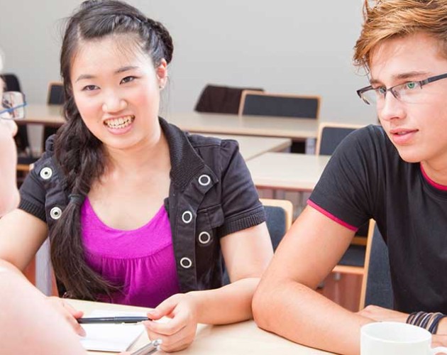 Photo of educational consultant working with two high school students