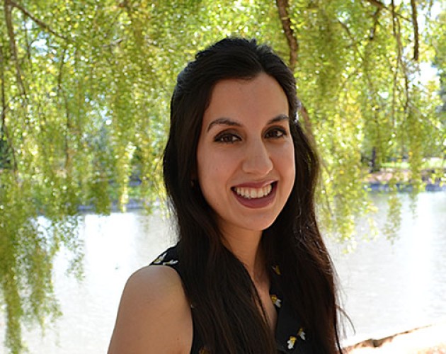 CLS Prep Program graduate Ester Fernandez standing by water, under a tree