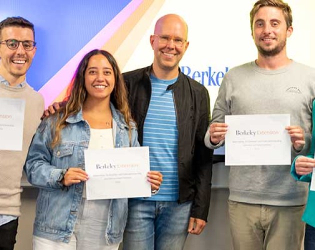 Graham Quigley (center) standing with graduates of a custom program