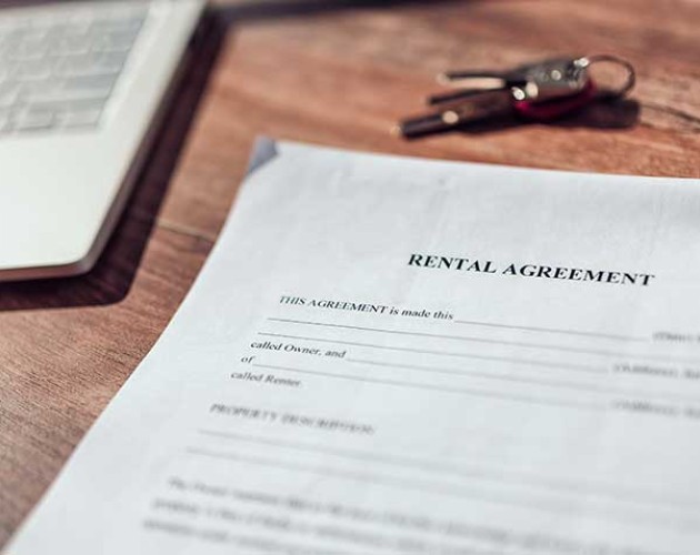 Photo of rental agreement paperwork next to a laptop