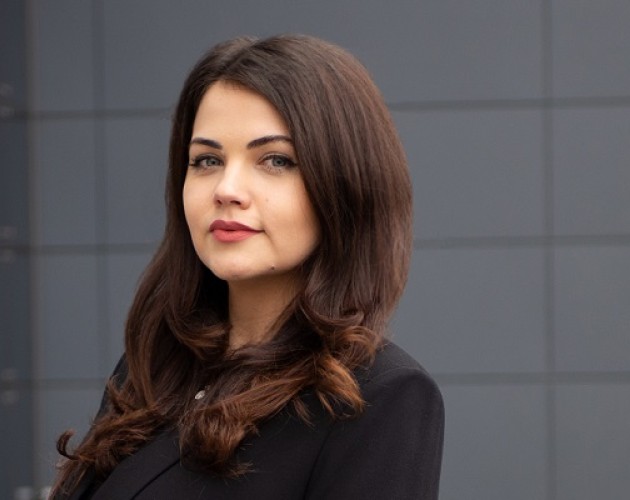 Photo of UX Design program graduate Iliyana Bozhanina in front of a dark gray building