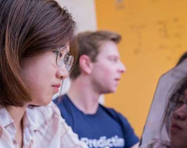 Close up photo of Iris Yuning working on laptop with mirror image of herself showing