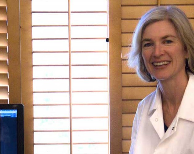 Photo of Jennifer Doudna next to a computer screen showing genome