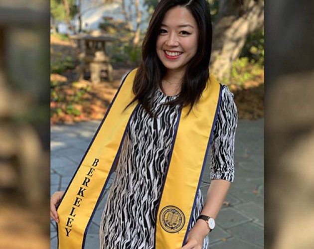 Jolin Wu wearing a Berkeley graduation scarf standing in front of some trees