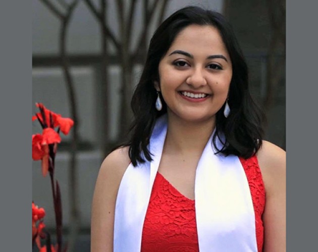 Post-Baccalaureate Program for Counseling and Psychology Professions graduate Karishma Bajaj outside in front of red flower