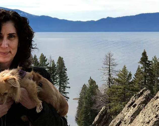 Marianna Lenoci posing in front of a Sierra lake while holding her puppy