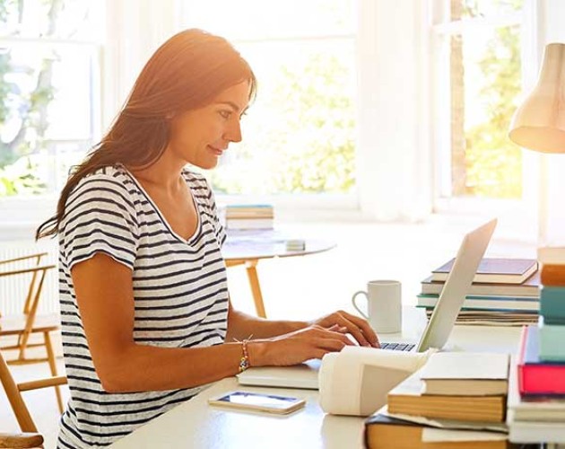 Woman typing on laptop in apartment room