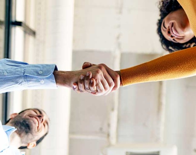 Photo looking up of two people shaking hands