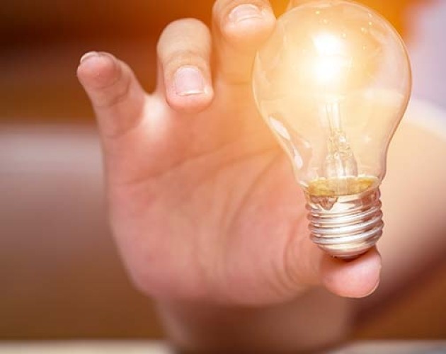 man holding lightbulb in foreground