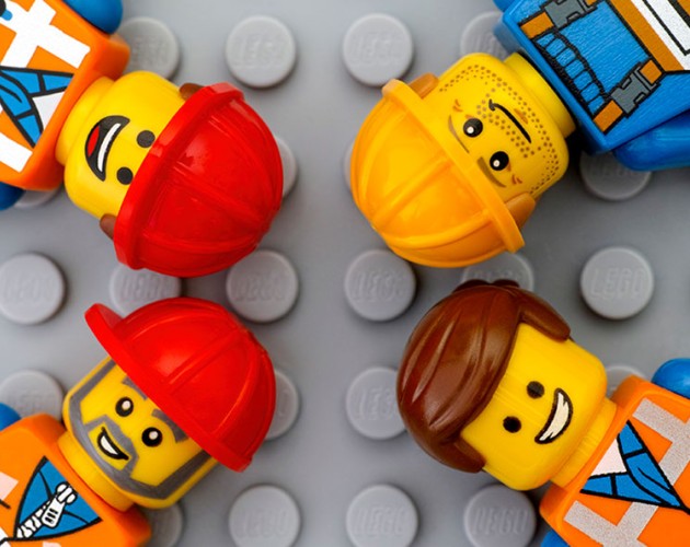 Still from lego movie with builders lying on a lego background