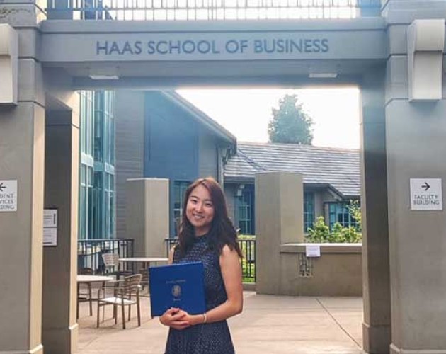 Photo of student Rioko Enomoto standing under Haas School of Business sign