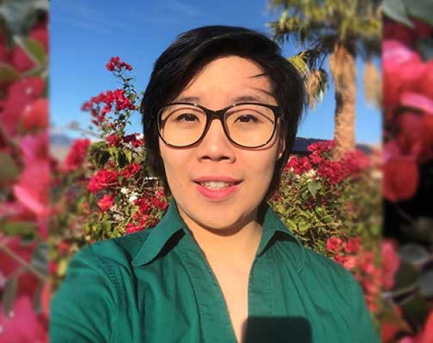 Photo of Robin Duong in front of a rose bush