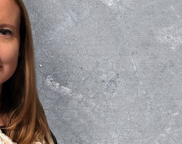 Sarah Sprague standing in front of a concrete wall