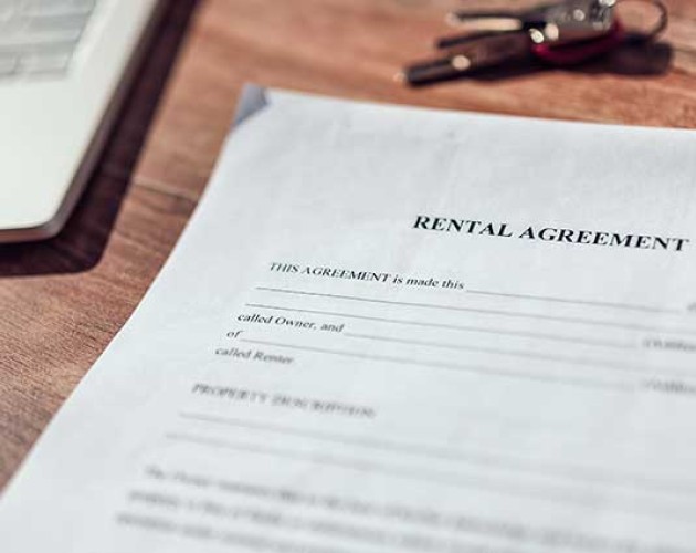 Photo of rental agreement paperwork next to a laptop