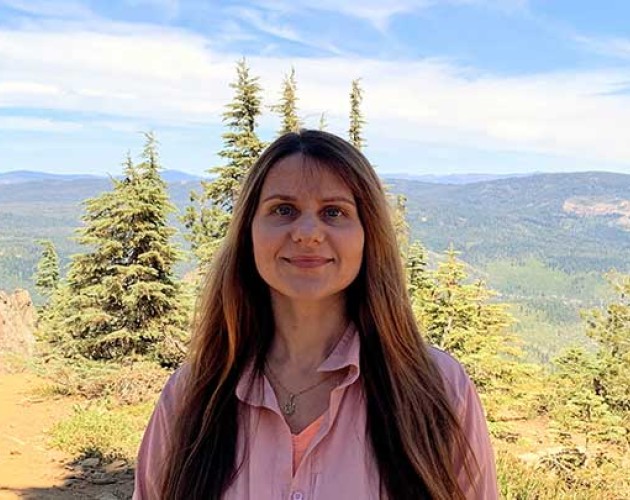 Photo of Tetiana Pairman in front of a forest and mountain background