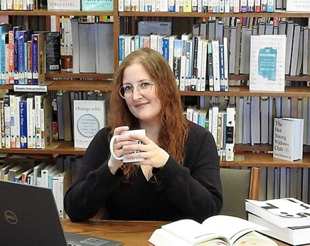 Editing student, scholarship winner Tracy Locken at a table in the library, with a laptop and books