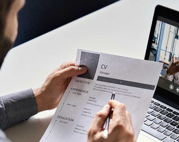 Male professional looking at CV with job applicant on a teleconferencing call