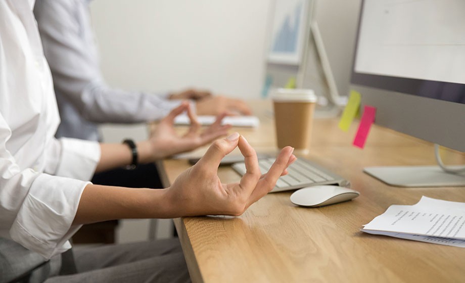 Office yoga for relaxation or concentration concept, calm businesswoman meditating at work, peaceful mindful employee practicing exercises at workplace, focus on female hands in mudra, close up view