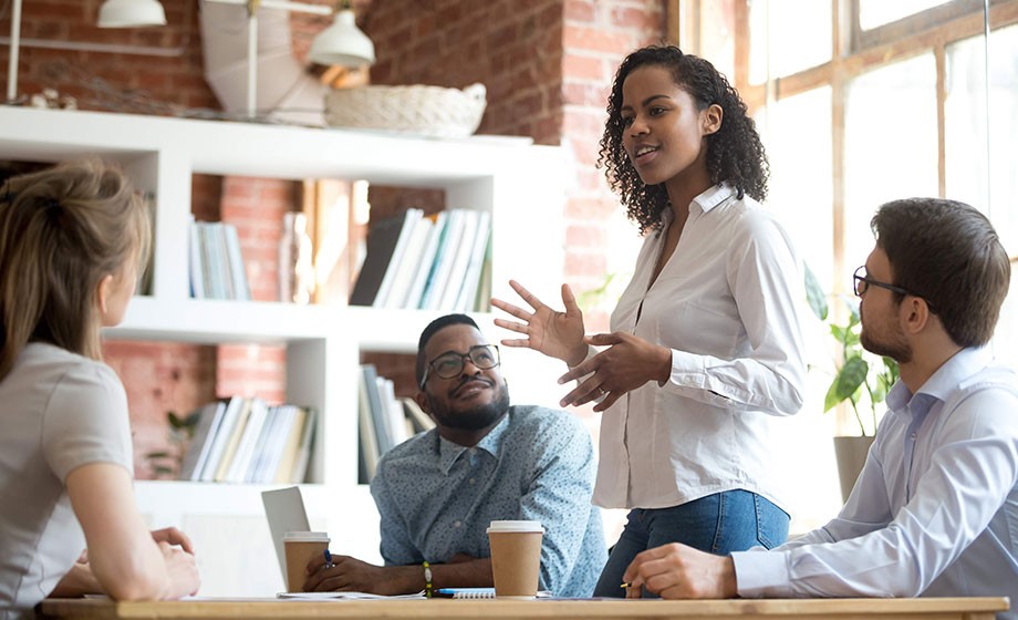 Black young female professional leading a meeting with colleagues